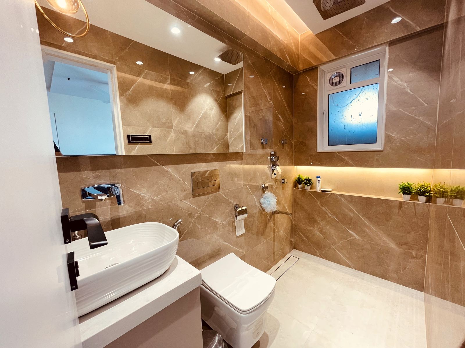 Bathroom in brown marble with black fittings, Mumbai