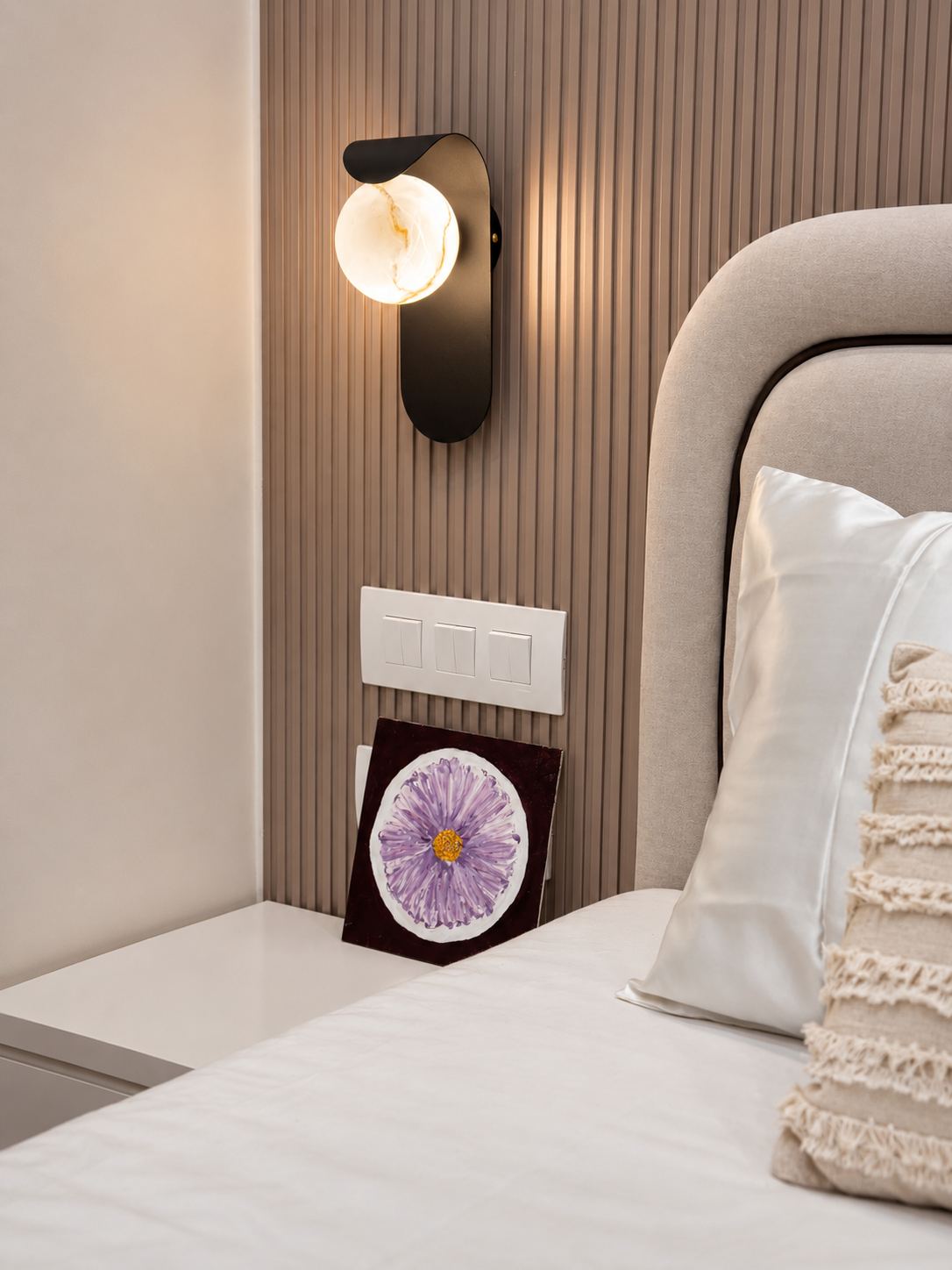 Bedside detail with fluted panelling and black sconce