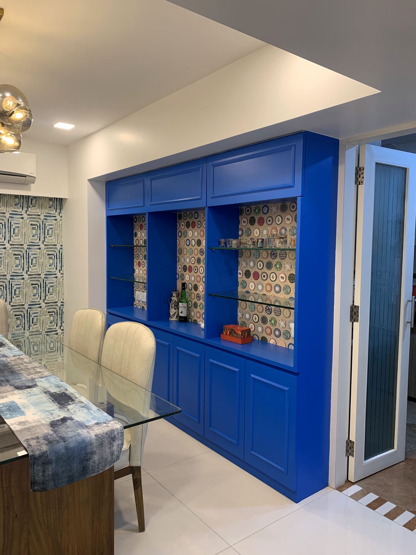 Dining area with cobalt blue crockery cabinet, statement interior Mumbai